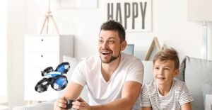 Padre e hijo pilotando drones para niños Holy Stone HS210 en el salón – foto oficial del fabricante